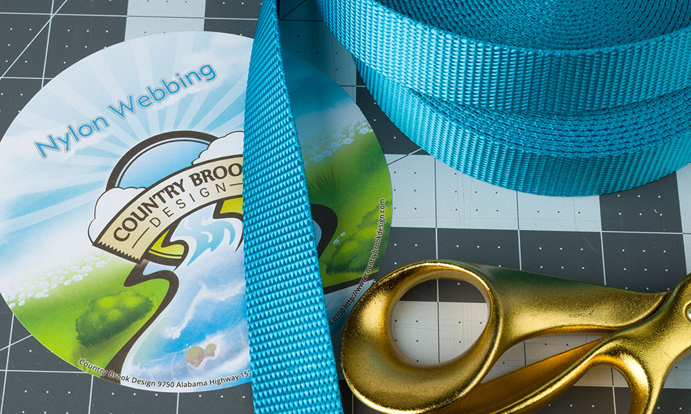 Ice Blue Nylon Webbing paired with scissors on a sewing mat