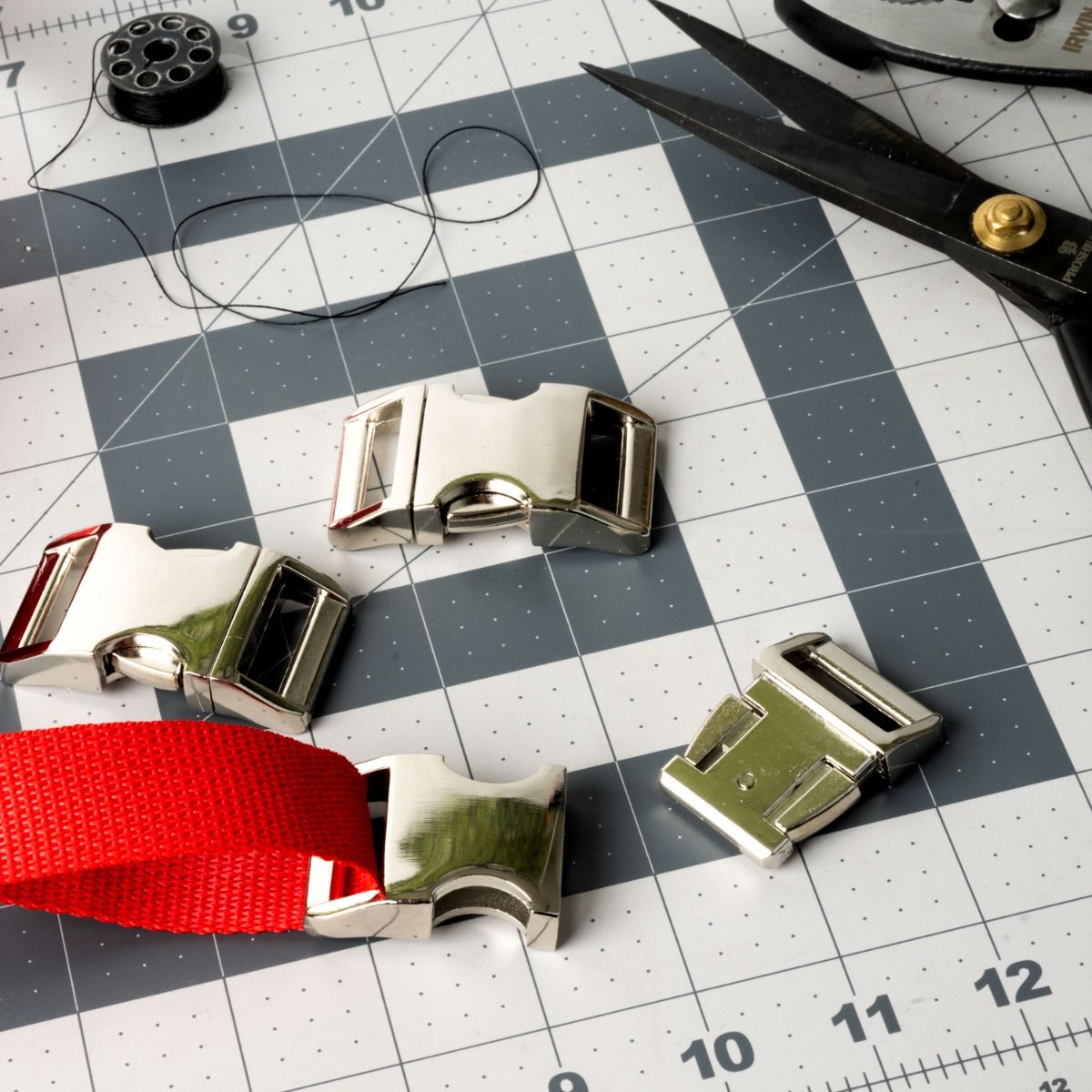 A photo showing several contoured metal side release buckles being used in a sewing project.