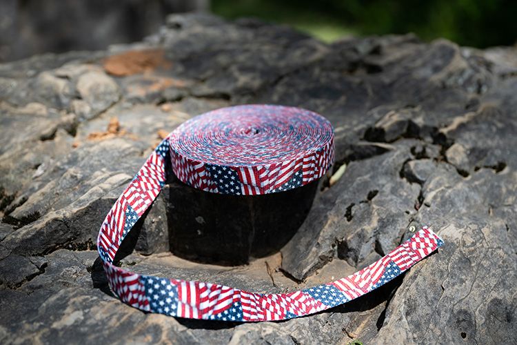 1 Inch Patriotic Tribute Polyester Webbing laid on top of rocks